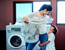 Lets First Finish The Laundry Then We Can Play. Cropped Shot Of A Young Attractive Mother Doing Laundry With Her Son At Home.