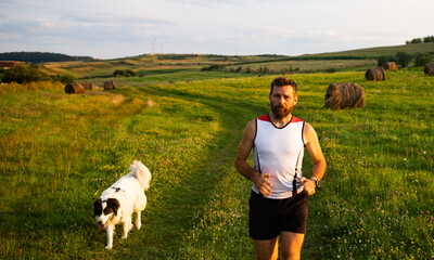 Wall Mural - man running with his dog at sunset healthy active lifestyle