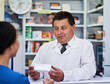 © Nikish H/peopleimages.com - Take this 3 times a day. Shot of a male pharmacist helping a female customer in a pharmacy.