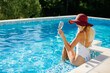 © shevtsovy - happy woman relax in swimming pool on summer vacations. Sexy woman in swimsuit splashing water drops and having fun. Summer vacation time.