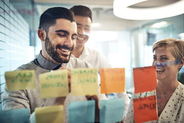 Canvas Print - Success is theirs with these great ideas. Shot of businesspeople brainstorming with sticky notes on a glass wall in the office.