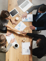 Aufkleber - Lets work together to win together. High angle shot of a group of businesspeople shaking hands during a meeting in an office.