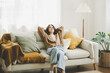 © Monster Ztudio - Happy asian woman relaxing on comfortable soft sofa enjoying stress free weekend at home, She stretching on couch thinking of pleasant lazy day