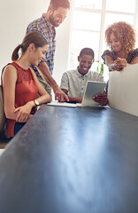 Canvas Print - They love what hes come up with. Shot of a group of colleagues working together on a digital tablet in an office.