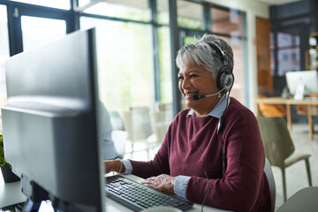Poster - She cares about every customer. Shot of a mature woman working on a computer in a call centre.