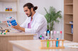 © Elnur - Young male chemist sitting at the desk in the classroom