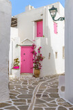 Fototapeta Uliczki - Traditional Cycladitic alley with narrow street, whitewashed houses and a blooming bougainvillea in Marpissa Paros island, Greece.