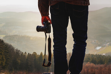 Photographer with camera in sunset taking photos of landscape. Travel Lifestyle hobby concept adventure active vacations outdoor