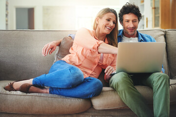 Sticker - Sofa movie dates are the best. Shot of a happy mature couple using a laptop together on the sofa at home.