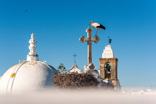 Portugal, Algarve, Olhao, White Stork Perching On Rooftop Cross Of Igreja De Nossa Senhora Do Rosario Church