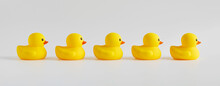 Yellow Rubber Ducks Arranged In A Row On White Background