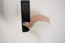 Woman Unlocking Smart Door Of House With Fingerprint