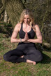 © Liz Mitchell - Woman practicing yoga outdoors in woodland