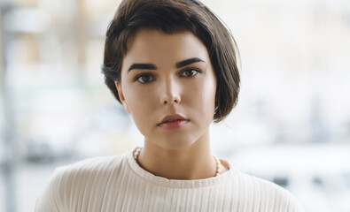 Portrait of beautiful young woman with brown eyes and short hair.