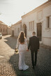 © Tobica - Wedding couple walking. The bride and groom holding hands.  The bride holds a bouquet in her hand.
