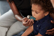 © DragonImages - Mother helping little son to use asthma inhaler against allergic attack