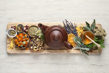 Clay Teapot, Honey And Different Dried Herbs On White Wooden Table, Top View