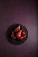 Wall Mural - pears in a black wooden plate on deep burgundy textured grunge background. place for text.
