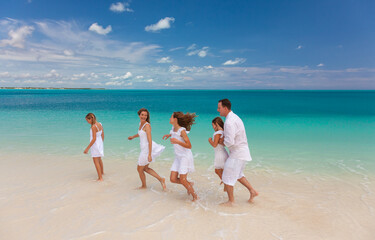 Wall Mural - Young Caucasian parents and children beach fun togetherness