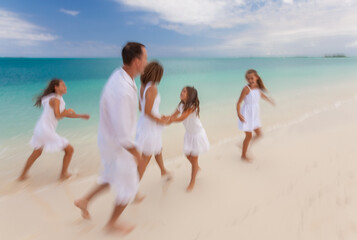 Wall Mural - Happy Caucasian family white clothes running along beach