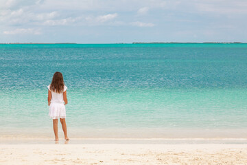 Wall Mural - Healthy young Caucasian child walking along Caribbean beach