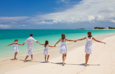 Wall Mural - Young Caucasian parents and children beach fun together