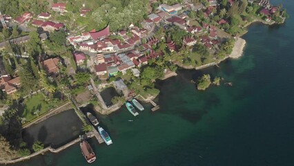 Sticker - Aerial: flying over lake Toba and Samosir Island Sumatra Indonesia. Tuk Tuk traditional village and tourist destination. Huge volcanic caldera water ecosystem, lush green equatorial forest.