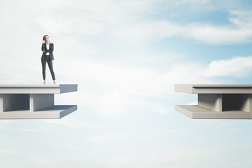 Canvas Print - Attractive pensive young businesswoman standing on bridge with gap and blue sky background with mock up place. Challenge and obstacle concept.