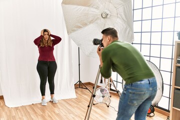 Canvas Print - Young woman at photography studio suffering from headache desperate and stressed because pain and migraine. hands on head.