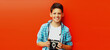 © rohappy - Portrait of happy little boy teenager with film camera on red background
