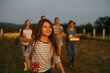 © Halfpoint - Happy farmer family holding their harvest outdoors in garden.