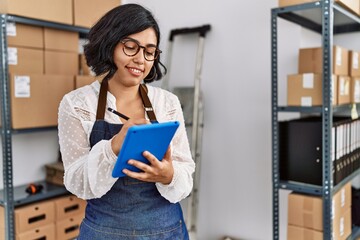 Sticker - Young latin woman ecommerce business worker using touchpad at office