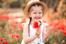 Happy Smiling  Girl Holding Red Poppy Flower In Meadow