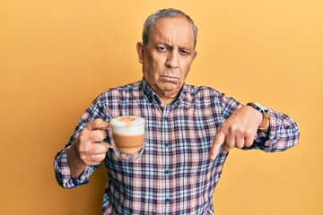 Sticker - Handsome senior man with grey hair drinking a cup coffee pointing down looking sad and upset, indicating direction with fingers, unhappy and depressed.