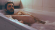 © Scopio - Naked man in foamy bathtub