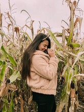 Side View Of Smiling Woman Standing In Corn Field