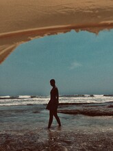 Silhouette Of Young Woman Standing On Seashore