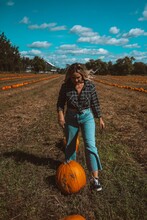 Woman In Field Holding Pumpkin In Pumpkin Patch Farm