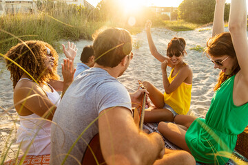 Outdoor fun on beach friends enjoying guitar music