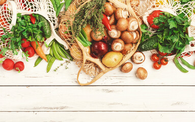 Wall Mural - Healthy food selection: mushrooms, beans, tomatoes, avocados, and herbs. Reusable shopping textile bags full of organic spring vegetables from local farmers market. Top view. Sustainable zero waste 