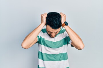 Canvas Print - Young hispanic man wearing casual clothes suffering from headache desperate and stressed because pain and migraine. hands on head.