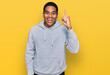© Krakenimages.com - Young handsome hispanic man wearing casual sweatshirt pointing finger up with successful idea. exited and happy. number one.