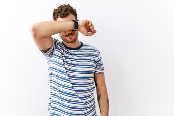 Poster - Handsome young man standing over isolated background covering eyes with arm, looking serious and sad. sightless, hiding and rejection concept