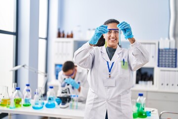 Wall Mural - Man and woman wearing scientist uniform hoding test tubes at laboratory