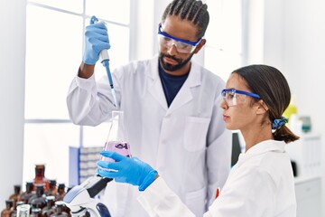 Sticker - Man and woman scientist partners working using test tube and pipette at laboratory