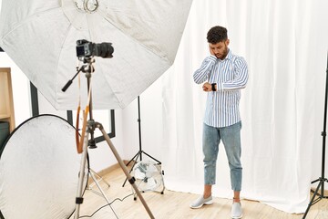 Sticker - Arab young man posing as model at photography studio looking at the watch time worried, afraid of getting late