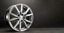 New Grey Alloy Wheels On A Dark Textured Black Background. Car Wheel , Copy Space Panorama Empty Space