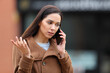 © PheelingsMedia - Angry woman in the street talking on phone