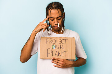 Young African American man holding protect our planet placard isolated on blue background