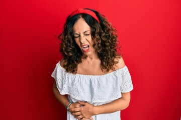 Canvas Print - Middle age hispanic woman wearing casual clothes with hand on stomach because indigestion, painful illness feeling unwell. ache concept.